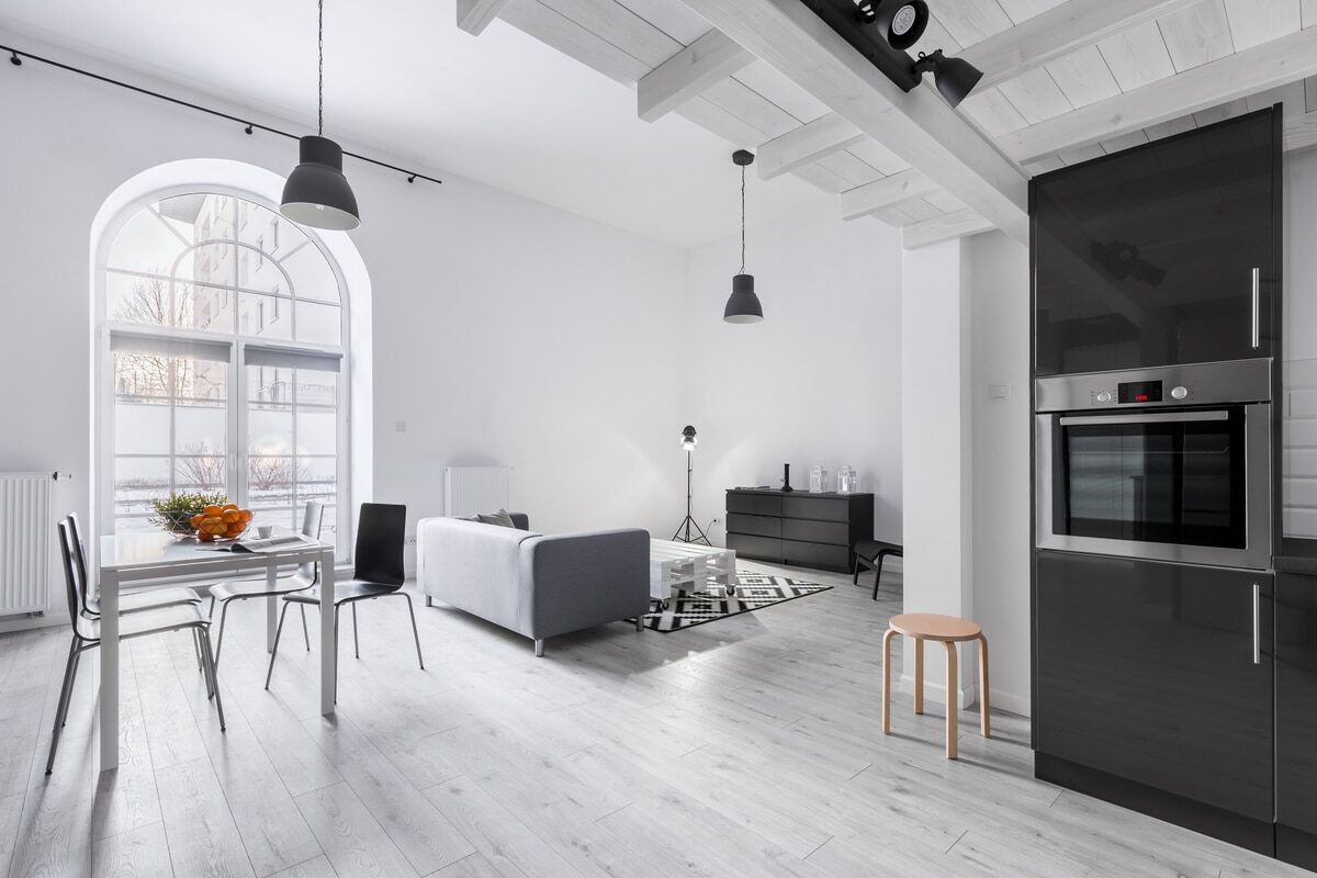 modern spacious kitchen living dining area with light gray laminate and white walls