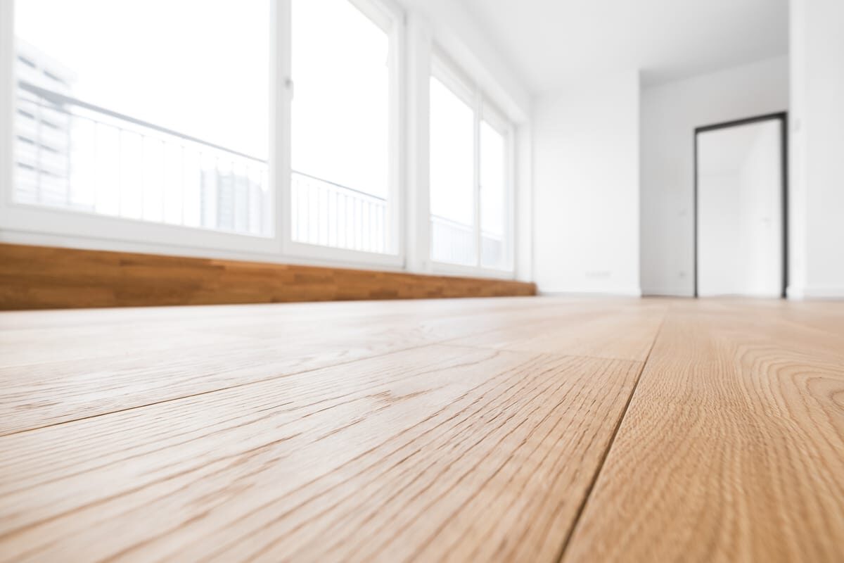 a close up of light hardwood flooring installed in a home