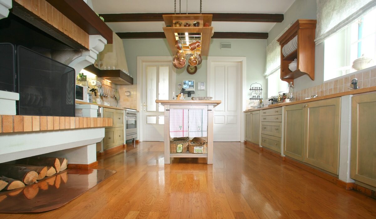 a vintage style kitchen with honey orange hardwood floors