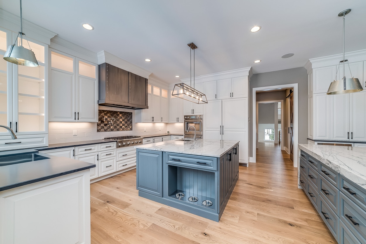 a modern kitchen with island and laminate floors