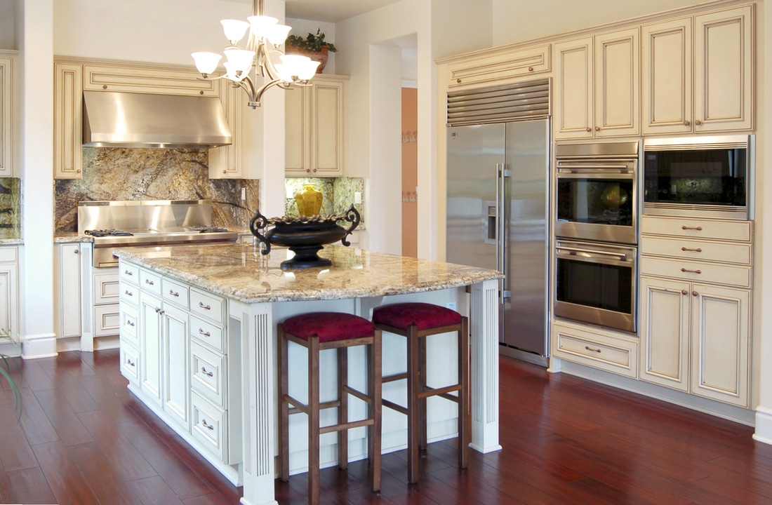 a modern kitchen with island and red wood floors