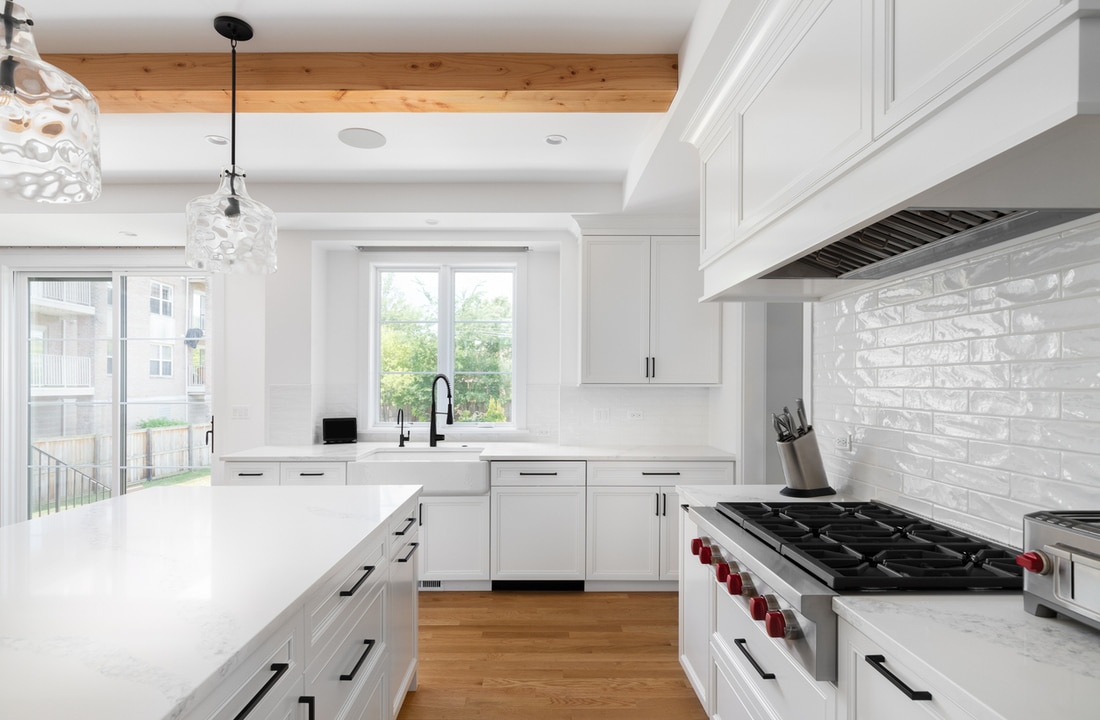 a kitchen with white cabinets and knotty pine floors