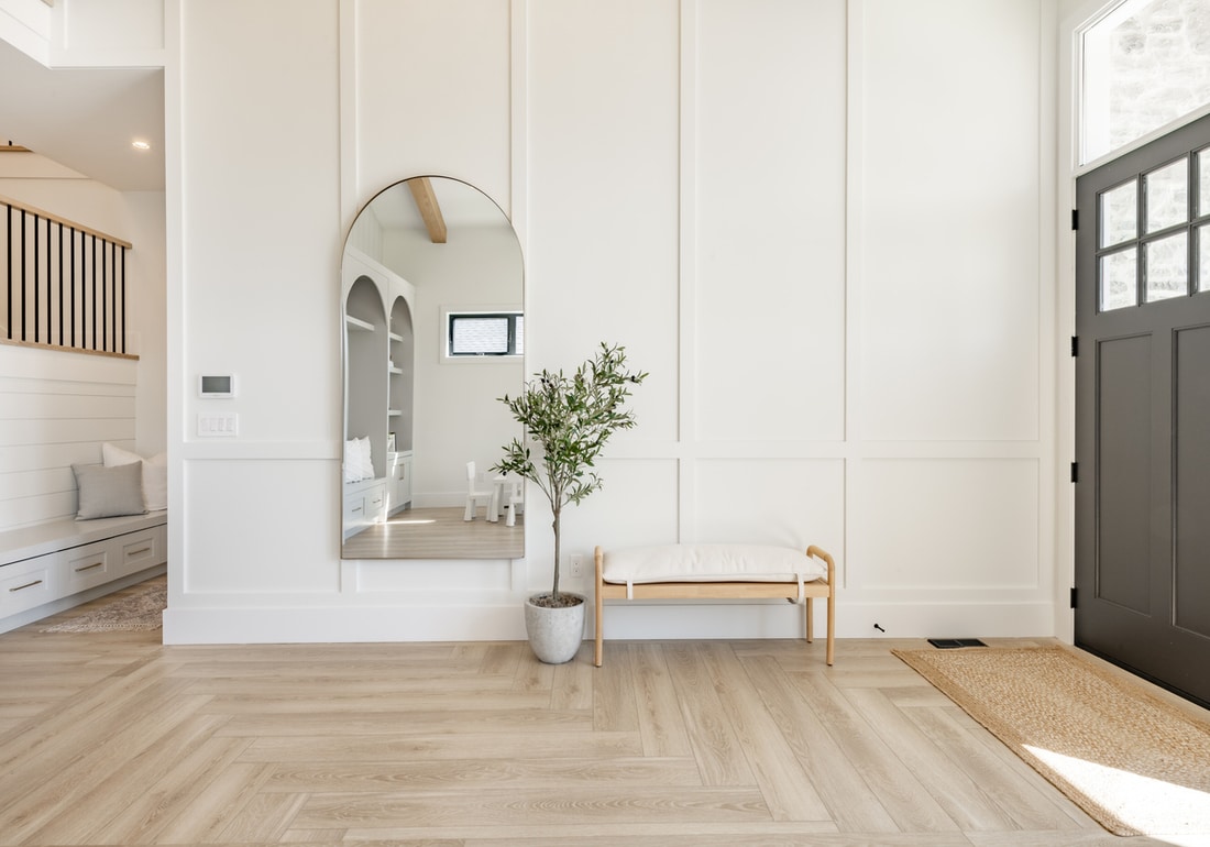 a hallway with modern herringbone floors and off white wall panels