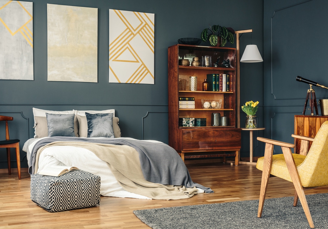 a bedroom with navy wall panels and strip plank wood floors