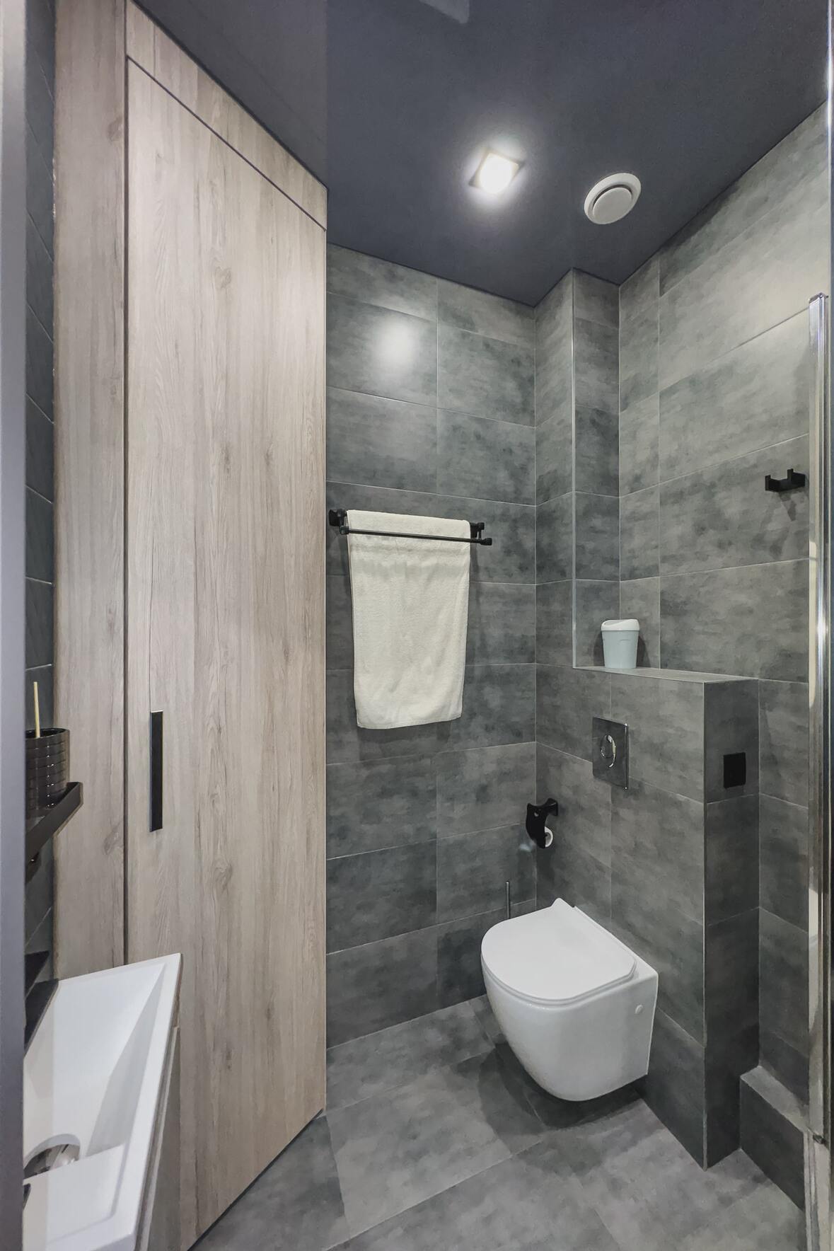 a small bathroom with dark gray vinyl tiles