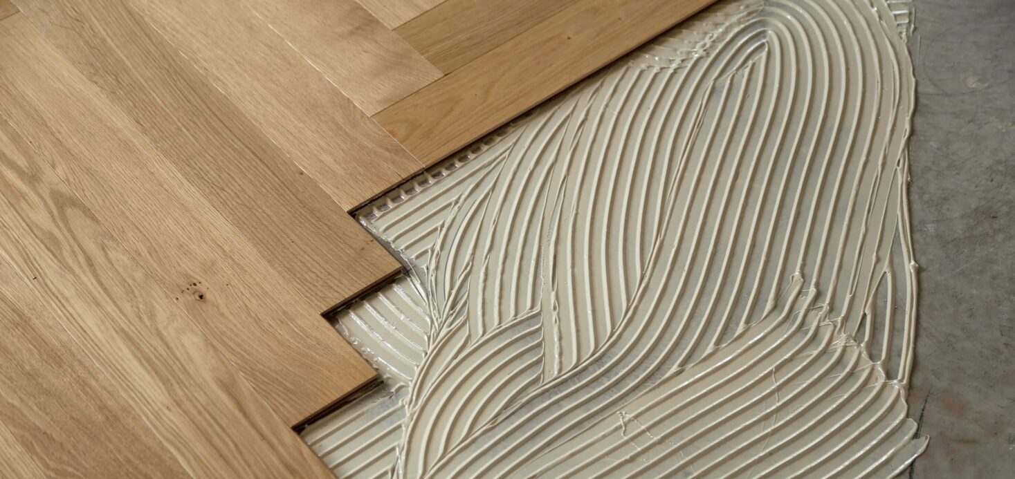 hardwood floor being installed using the glue-down method with adhesive