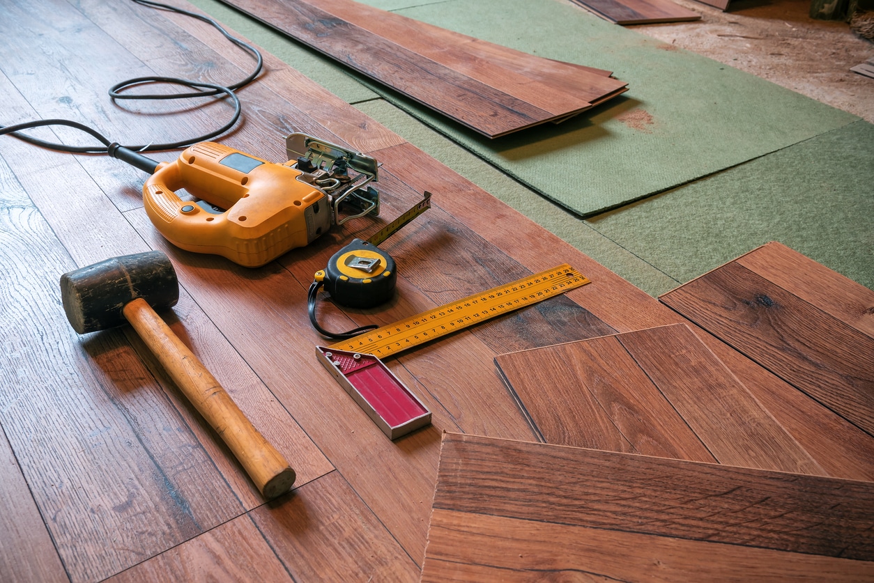 installing hardwood floor using a nailer powertool
