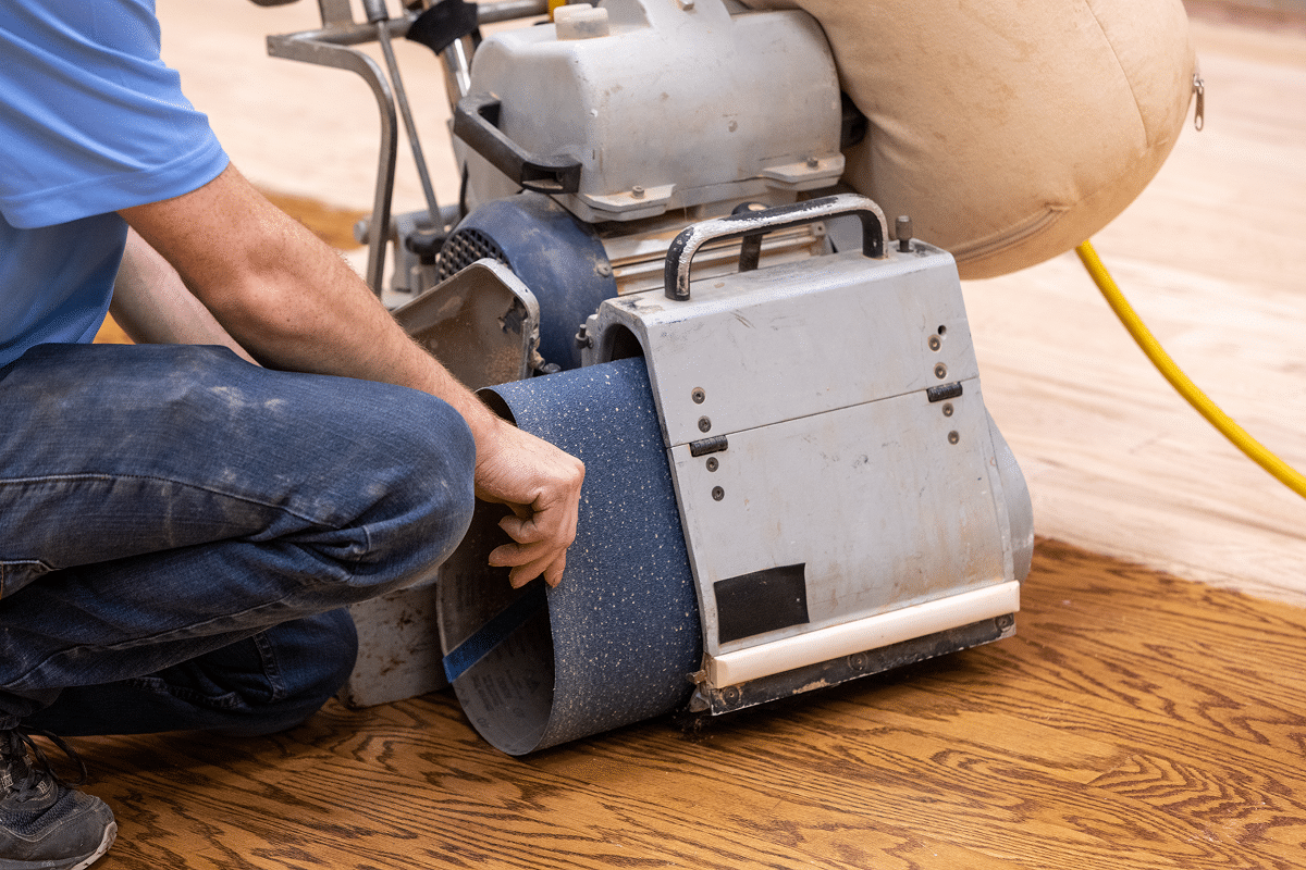sanding belts being changed in a drum sander for flooring